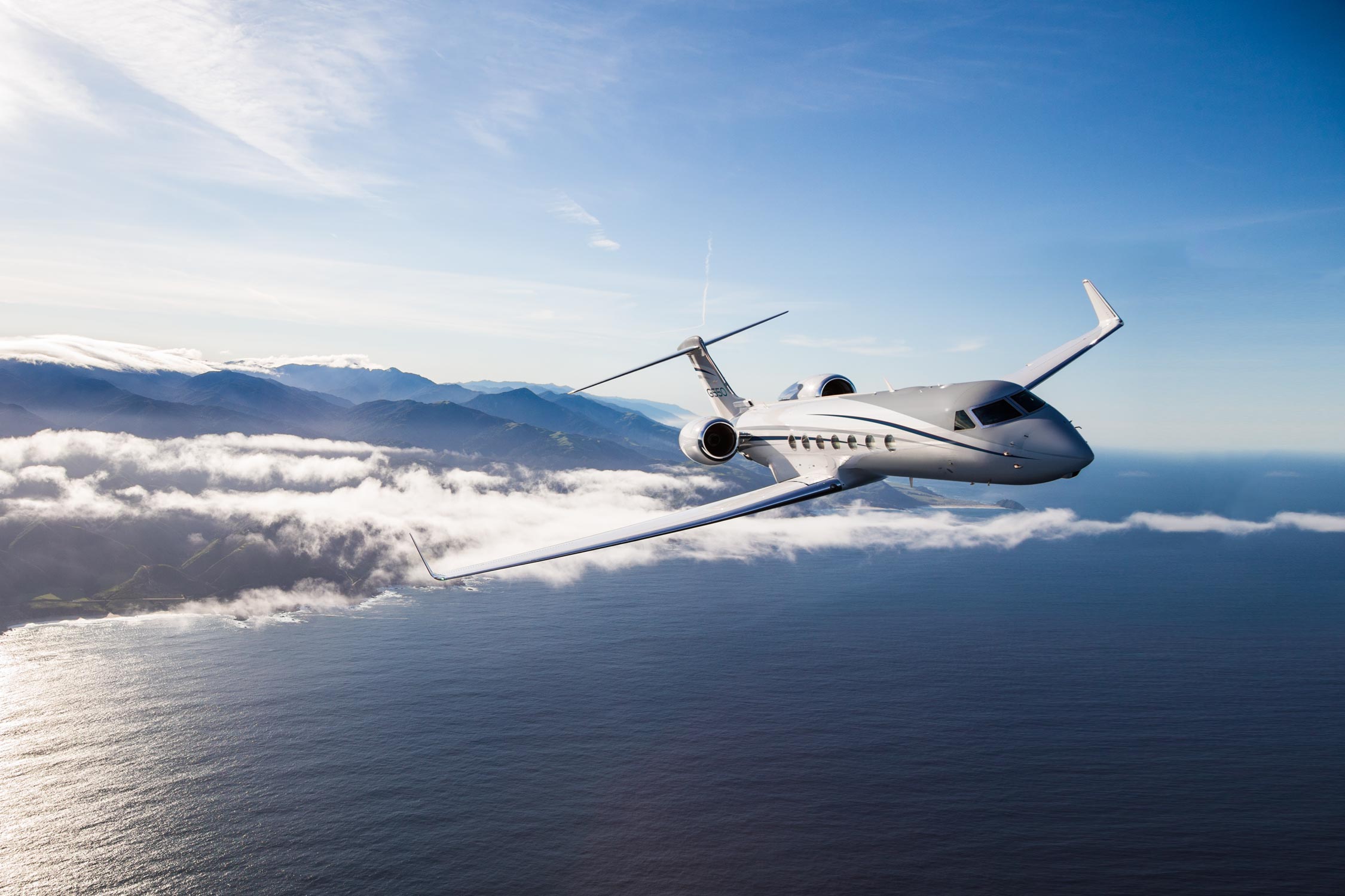 G550 flying above clouds and over water