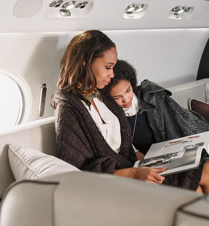 Mother reading to her daughter inside a private jet