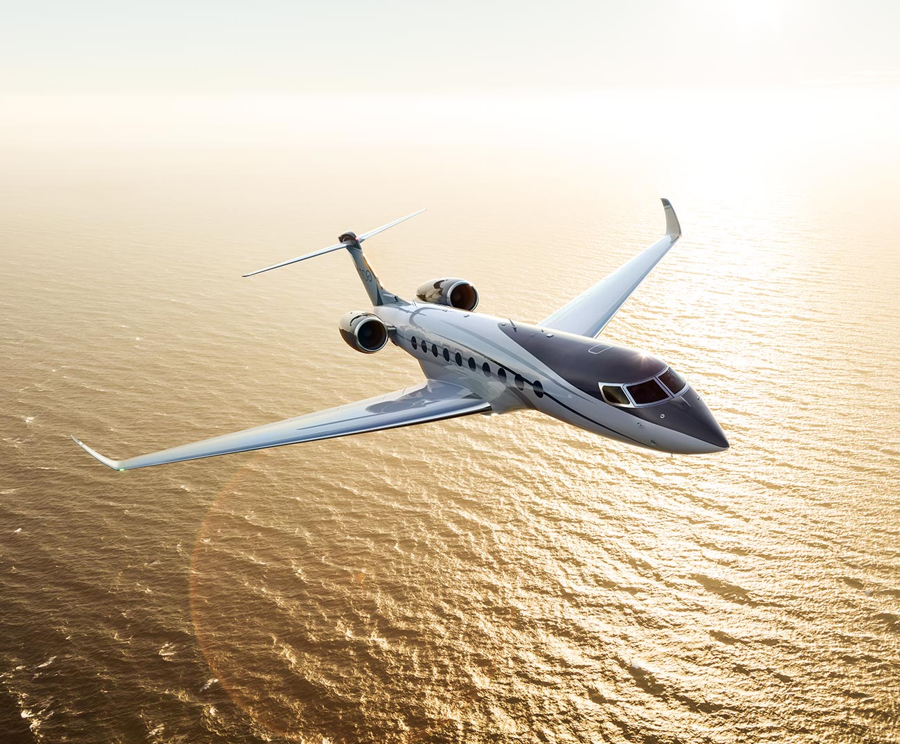 G700 flying at sunset over water