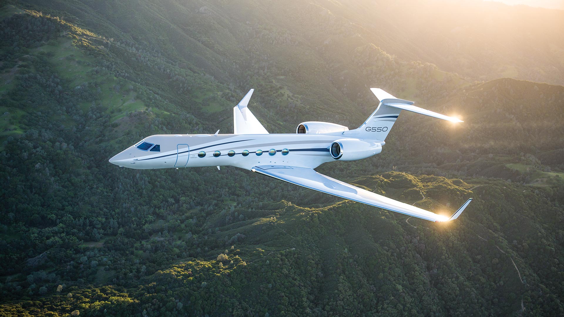 G550 aircraft flying over mountains