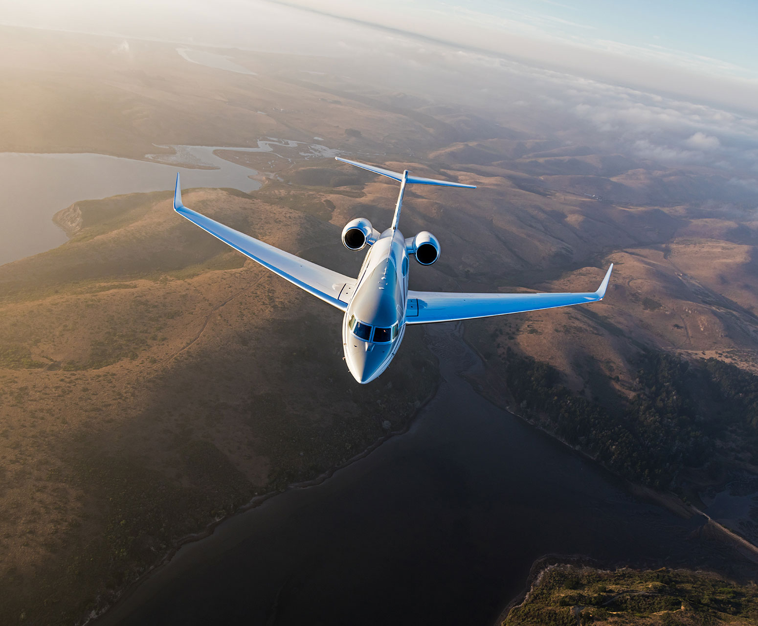 Airplane flying above green space and river