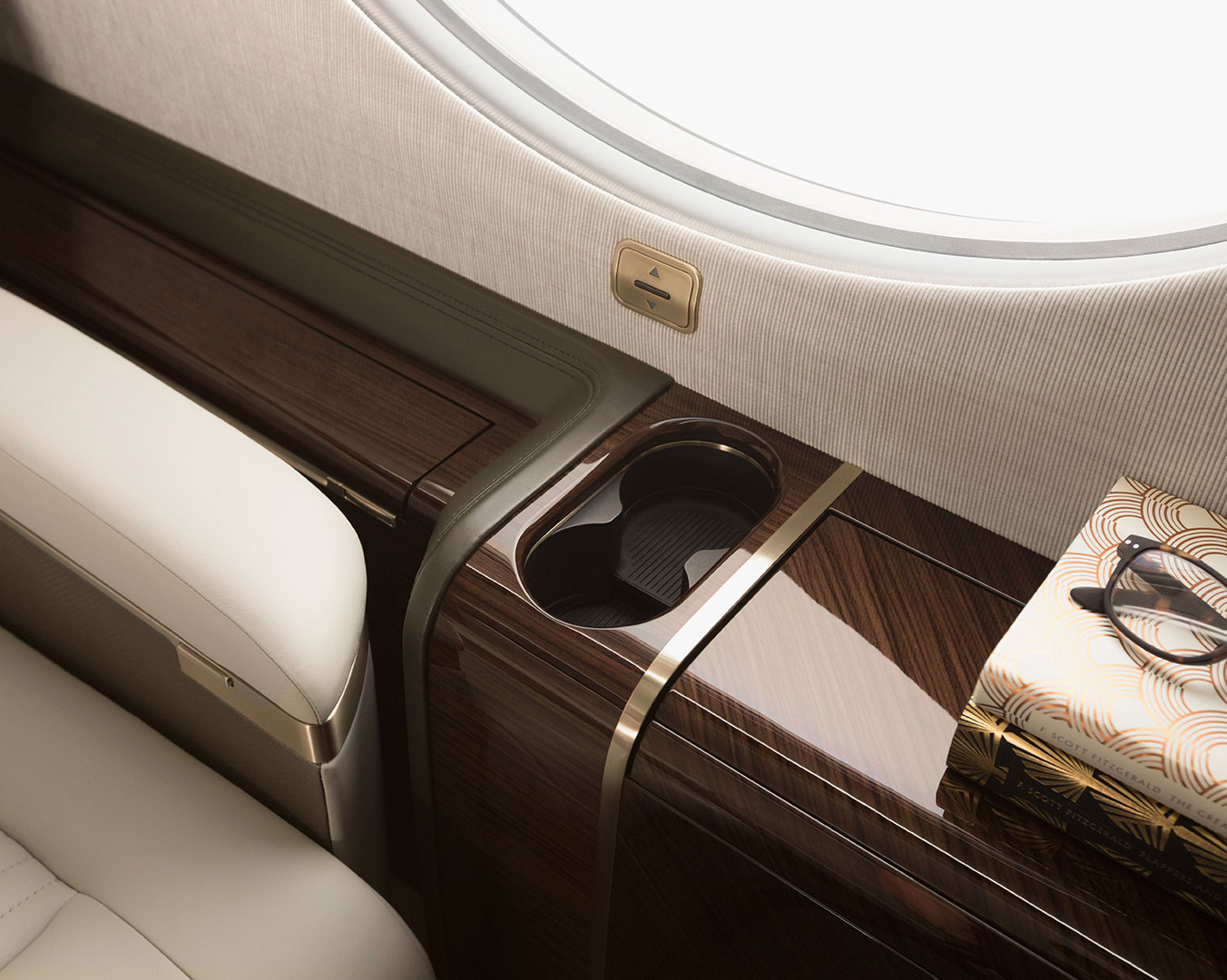 Close-up of cupholder and leather arm rest inside aircraft