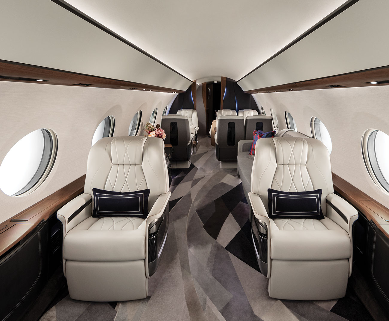 Two white leather chairs in luxury aircraft aisle