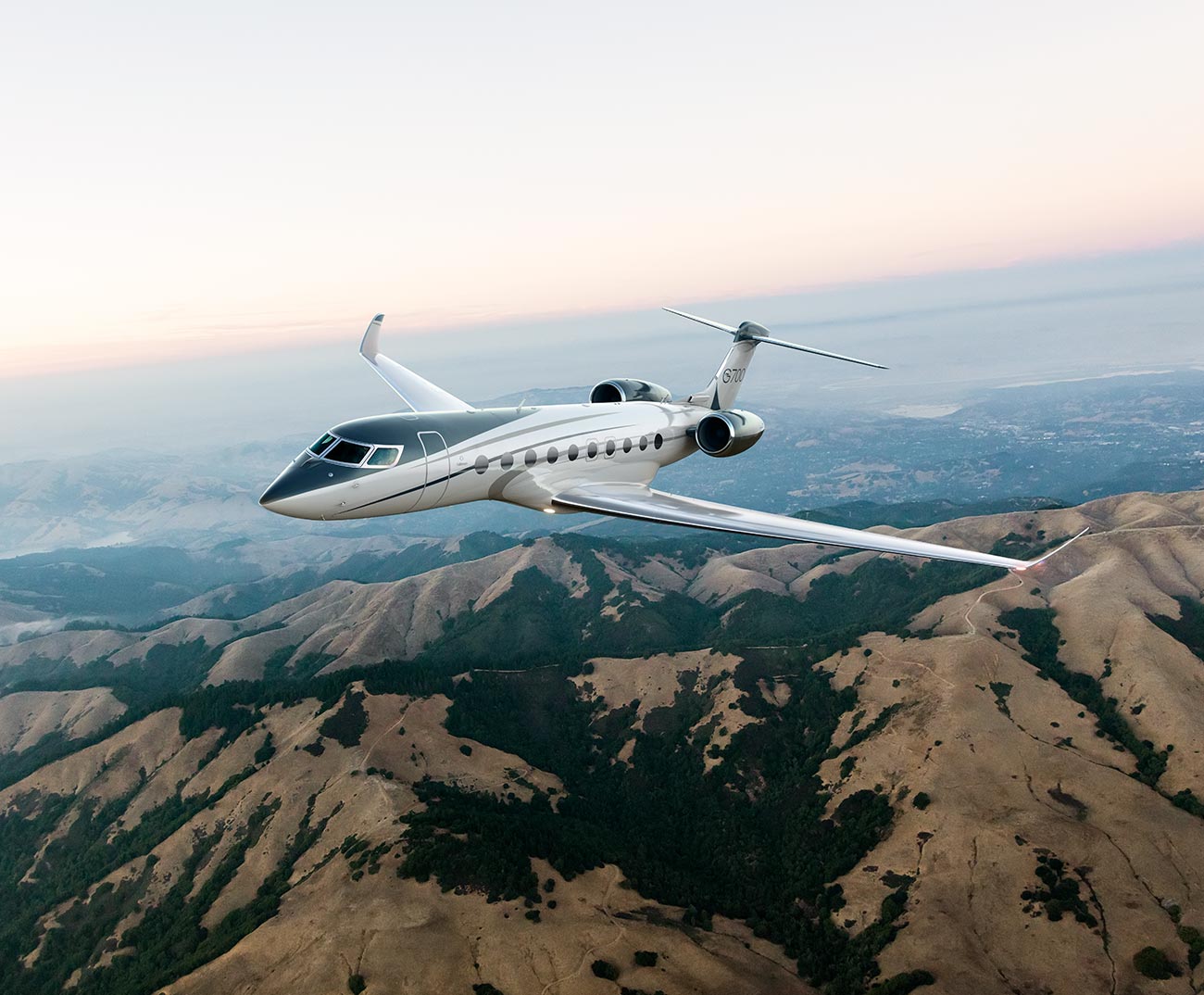 G700 flying over mountains