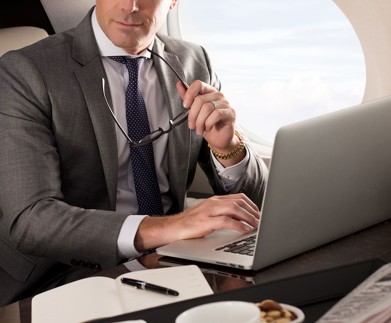 Man with glasses working on computer inside G500 aircraft