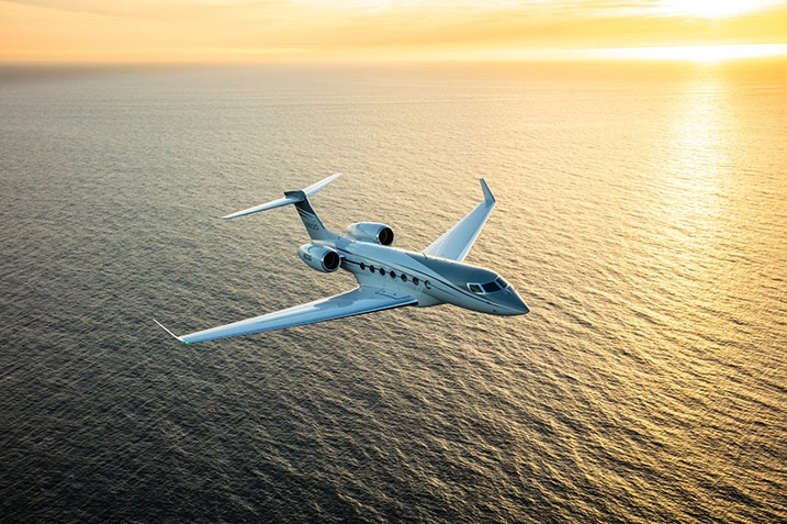 G600 Flying Over Water at Sunset